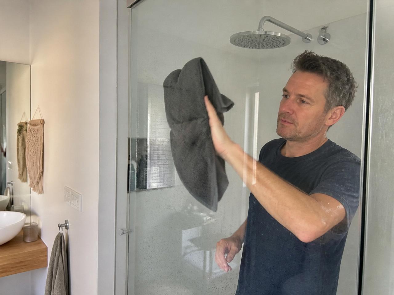 A man casually wiping the shower screen with a ClothWipe